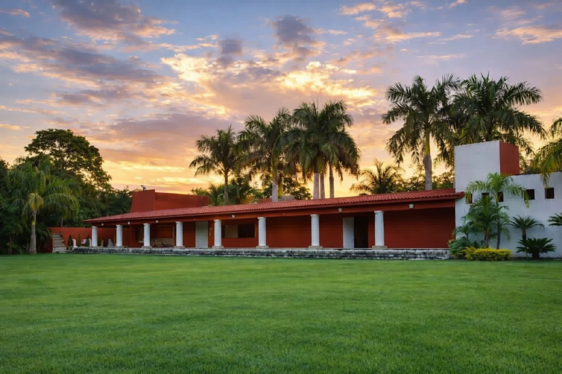 Vista amplia de jardines y hospedaje de Rancho Ixtla Las Palmas al atardecer